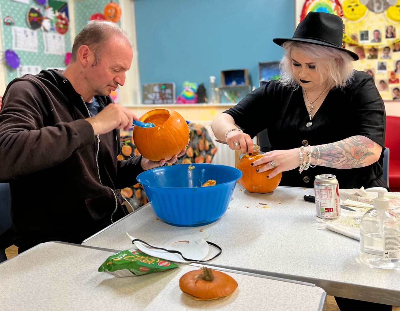A man and a woman are making Halloween lanterns out of pumpkins